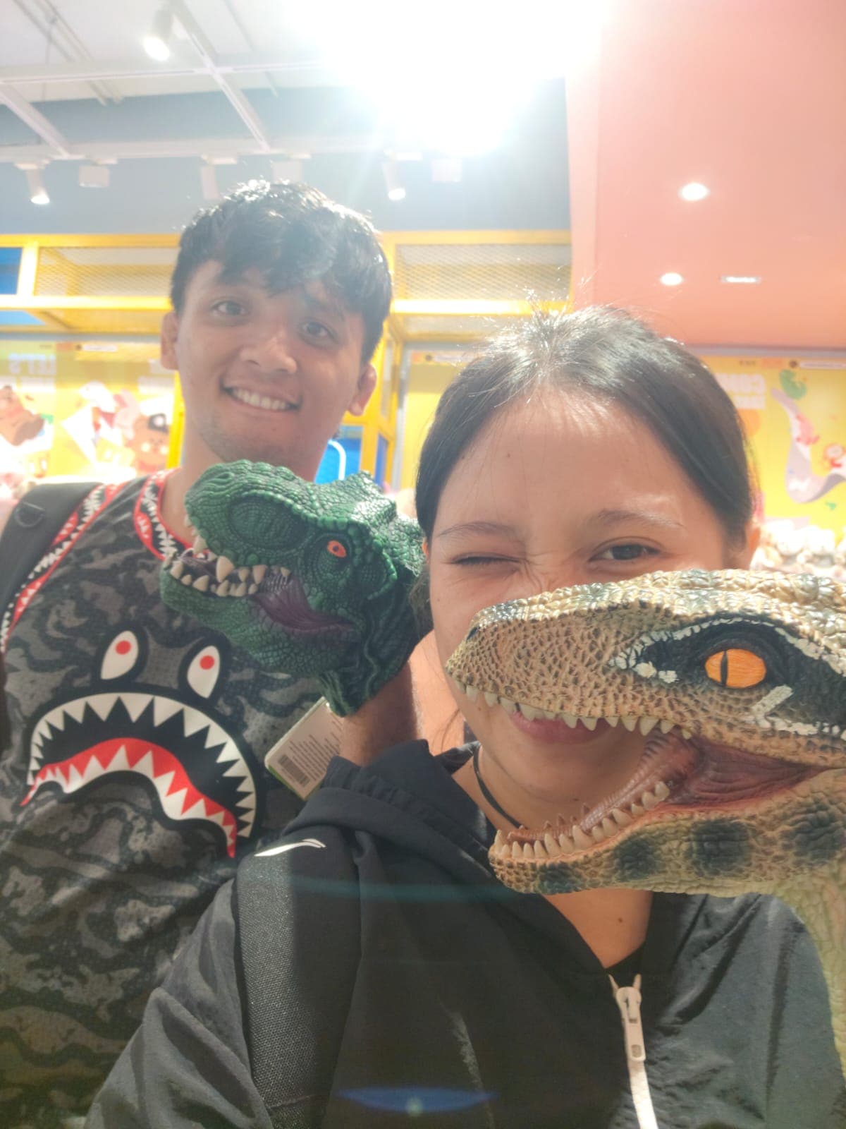 Brenda and Marck posing playfully with dinosaur toys